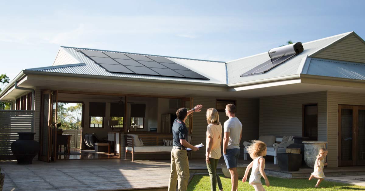 Solahart solar consultant with family inspecting solar system